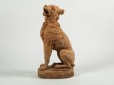 statue of a dog sitting on a pedestal with a white background