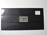 a black envelope with a stamp on it on a white surface