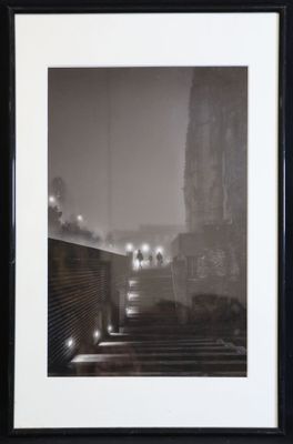 black and white photograph of a city street at night with lights on