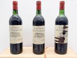 trois bouteilles de vin posées sur un support en bois