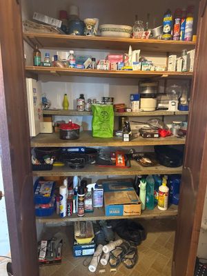 a pantry with a lot of clutter on the shelves