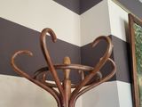 a wooden coat stand with a painting on the wall
