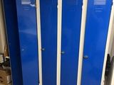 three blue lockers in the middle of a room