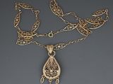 gros plan d'un collier en or auquel est attachée une chaîne