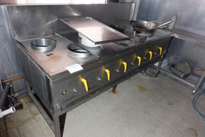 une cuisine équipée d'une cuisinière sur laquelle sont posées deux casseroles