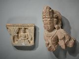 une petite statue représentant un homme coiffé d'une couronne, accrochée à un mur