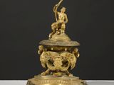 une figurine ancienne en laiton représentant un homme à cheval tenant une trompette