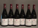 six bottles of red wine are lined up on a table