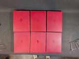 four red boxes on a table with a pair of scissors