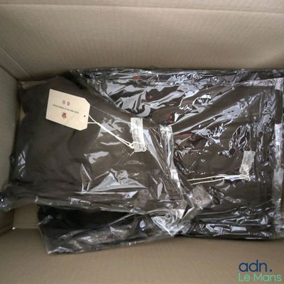 une boîte contenant une chemise emballée dans du plastique
