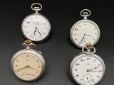 three different types of pocket watches on a black surface