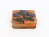 a soap dish with a flower on it on a white surface
