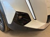 the front end of a white car with a black bumper