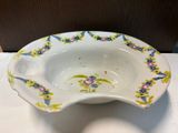 a white bowl with flowers on it on a table