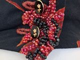 a black hat with red and black beads on it