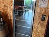 une cave à vin posée à côté d'un tonneau de vin dans une pièce