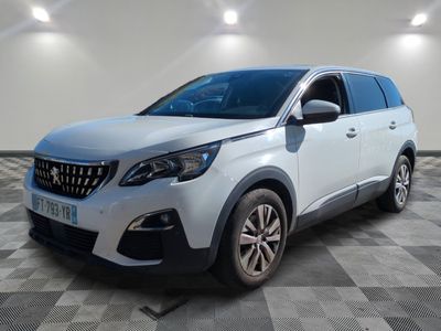une voiture blanche est garée dans une pièce au sol à carreaux