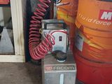 une machine posée par terre à côté de quelques fûts