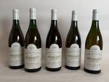 six bottles of wine are lined up on a table
