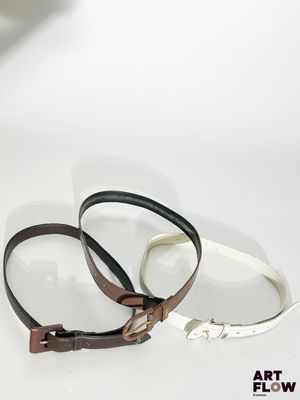 On voit deux morceaux de cuir posés sur une surface blanche