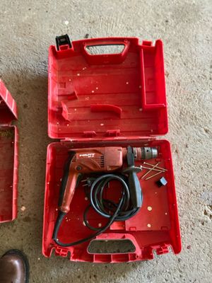 une boîte à outils rouge contenant une perceuse et une paire de chaussures marron