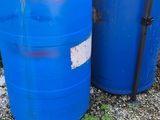 two blue barrels sitting next to each other on the ground