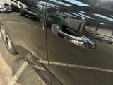 a black car parked in a parking lot with other cars in the background