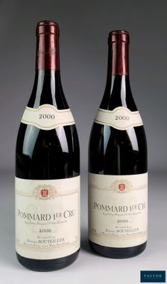 two bottles of red wine sitting next to each other on a table