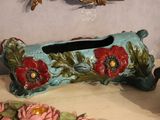 a tissue box with flowers on it sitting on a table