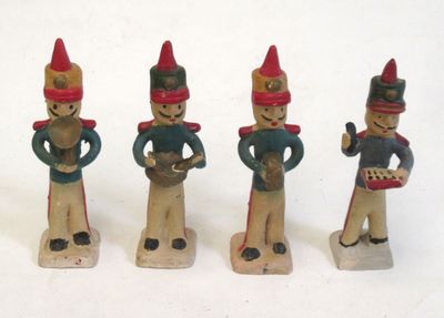 trois figurines en bois représentant un homme avec un tambour et un tambour