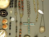 many different types of necklaces and bracelets laid out on a table