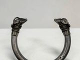 un gros plan d'un bracelet en métal orné de deux oiseaux