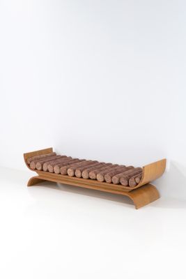 un plateau en bois sur lequel sont disposées des saucisses, posé sur une surface blanche