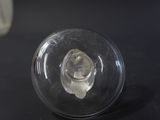 a glass bottle with a small piece of ice inside of it