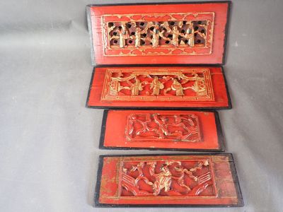 trois boîtes rouges ornées de sculptures, posées sur une table