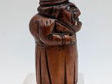 an image of a wooden sculpture of a man holding a cat
