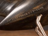 a bronze sculpture of a bird on a wooden table