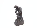 statue représentant un homme tenant un oiseau sur un rocher