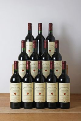 des bouteilles de vin rouge sont posées sur une table en bois devant un mur blanc