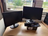 two computer monitors sitting on a desk next to each other
