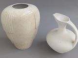 deux vases blancs posés l'un à côté de l'autre sur une table