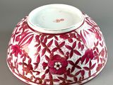 a red and white bowl with a floral design on it