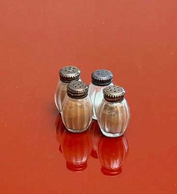 two salt and pepper shakers sitting on a red table