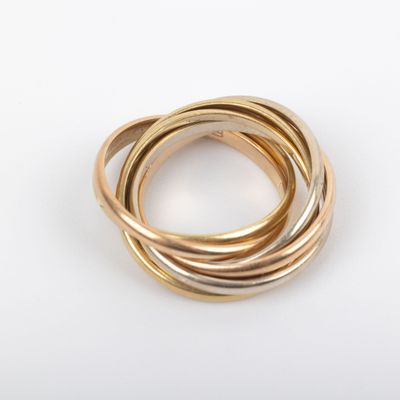 three gold rings stacked on top of each other on a white surface