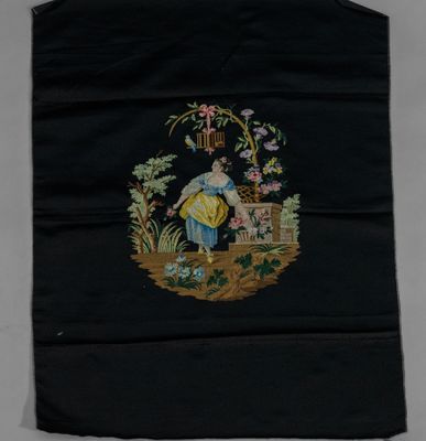 an old embroidered black bag with a woman and flowers on it