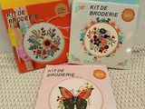 two cross stitch kits and a book on a table