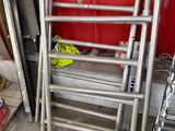 a stack of ladders sitting next to a red wall