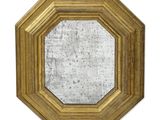 une image d'un miroir encadré d'or sur un mur blanc