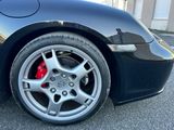 un gros plan d'une voiture noire avec un disque de frein rouge