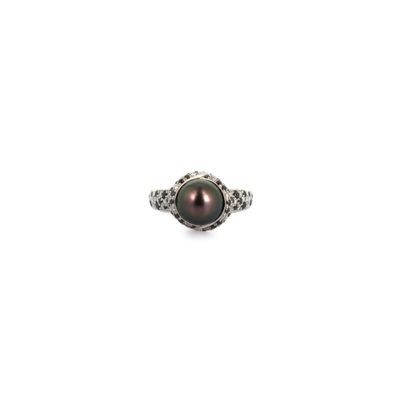 a close up of a black pearl ring on a white background
